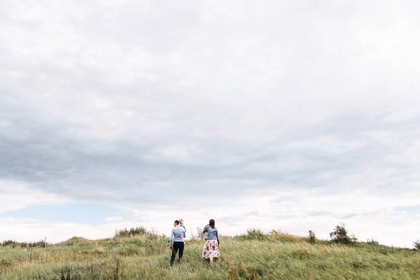 Pohled zezadu na rodinné procházky na louce v kalné den - Fotografie, Obrázek