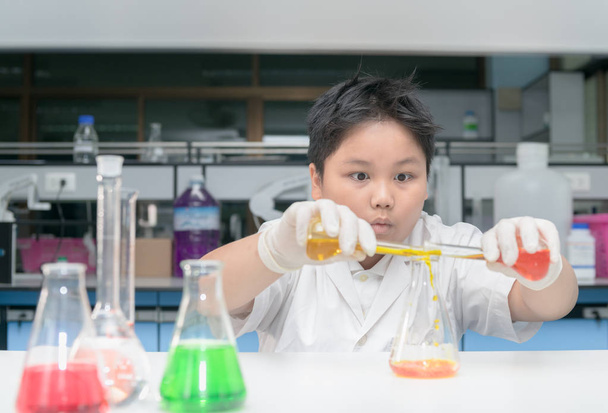kid scientist in lab coat making experiment  - Foto, Imagem