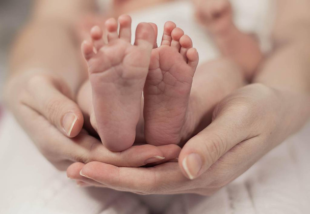 Gros plan sur les pieds du nouveau-né. Les pieds du bébé dans les mains de la mère. Bébé. Confortable. L'amour. Famille
. - Photo, image