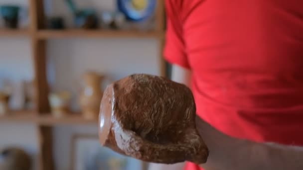 Alfarero masculino profesional examinando taza en taller de cerámica
 - Metraje, vídeo