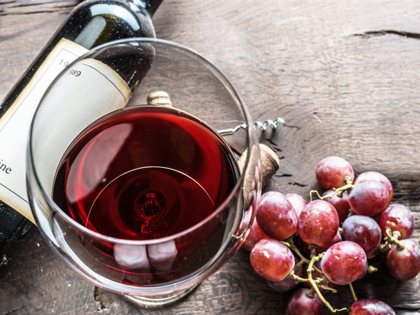 Wine glass, wine bottle and grapes on wooden background. Wine ta - Fotó, kép