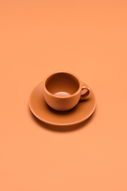 close up view of empty cup on saucer isolated on peach - Foto, Imagem