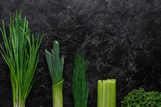 top view of green onion, leek and chives on concrete table, healthy eating concept - Fotó, kép