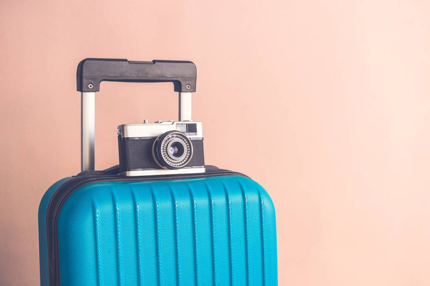 Luggage with vintage old fashioned camera on beige background minimalistic vacation concept - Foto, immagini