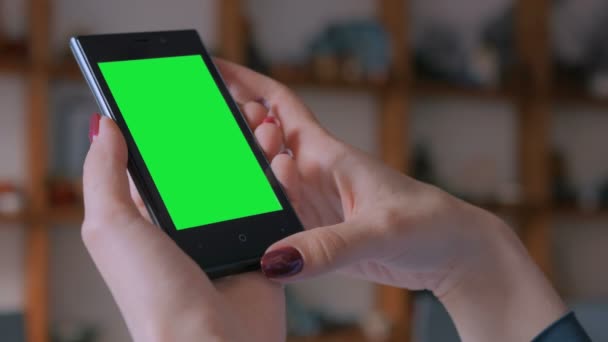 Frau schaut auf Smartphone mit Greenscreen - Filmmaterial, Video