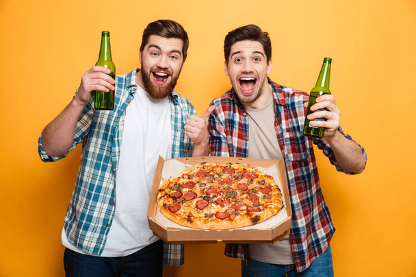 Portrait of a two cheerful young men drinking beer - Φωτογραφία, εικόνα