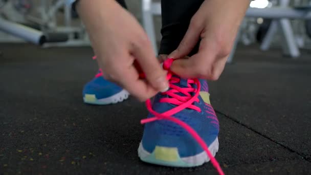 Running shoes - woman tying shoe laces in the gym - Filmati, video