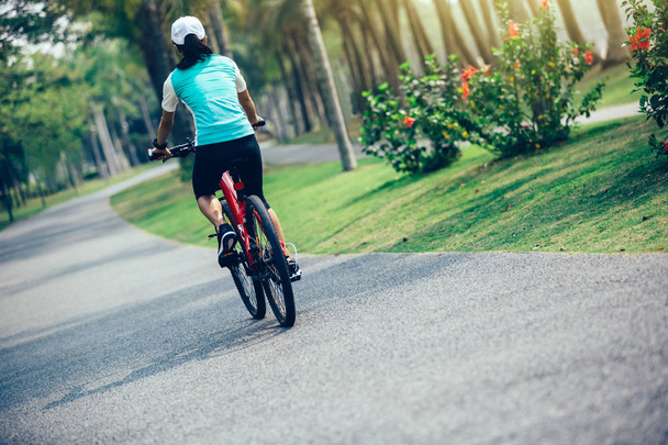 woman cyclist riding bike on forest trail - Foto, imagen