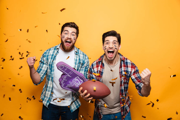 Portrait of a two excited young men holding rugby ball - Foto, immagini