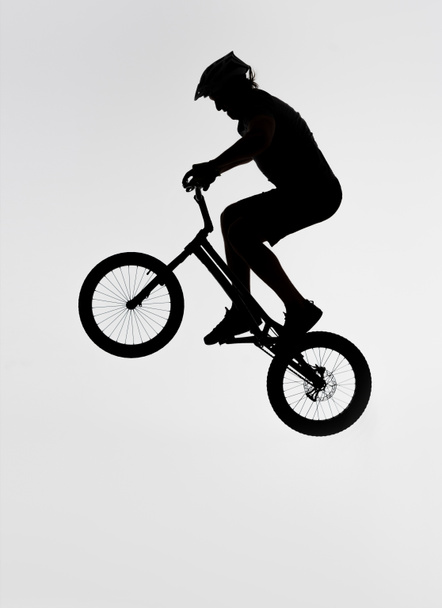 silhouette of trial biker jumping on bicycle on white - Photo, Image