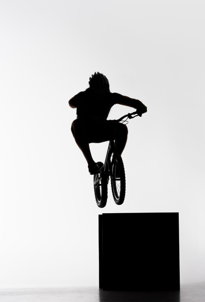 silueta del motociclista de trial saltando en cubo en blanco
 - Foto, Imagen