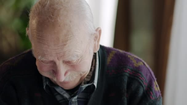 The old man in the cafe tells jokes, smiles and remember the past. - Video