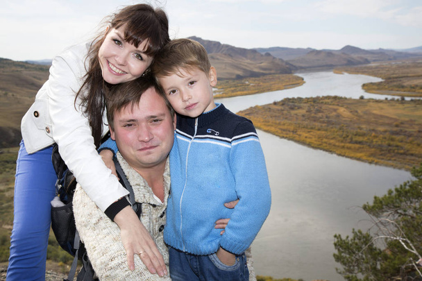 Uma família feliz na montanha com vista para a corrente sob o
 - Foto, Imagem