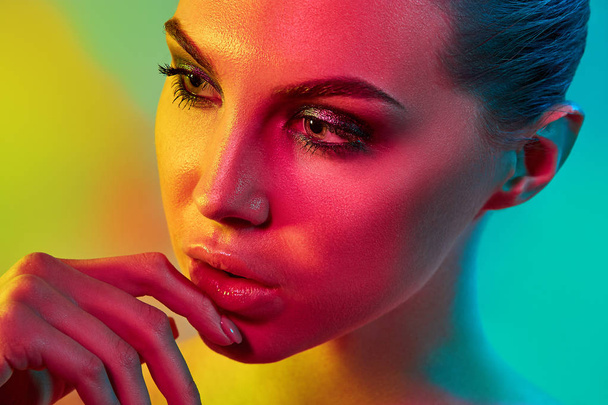 High Fashion model woman in colorful bright lights posing in studio - Фото, зображення