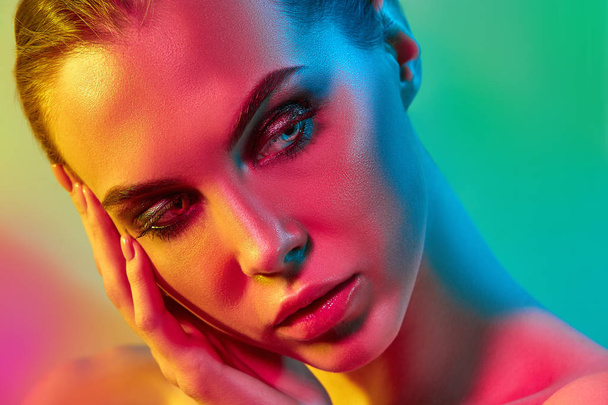 High Fashion model woman in colorful bright lights posing in studio - 写真・画像