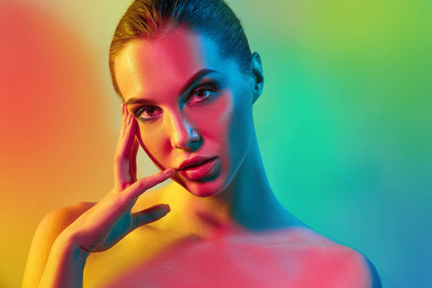 High Fashion model woman in colorful bright lights posing in studio - Foto, afbeelding