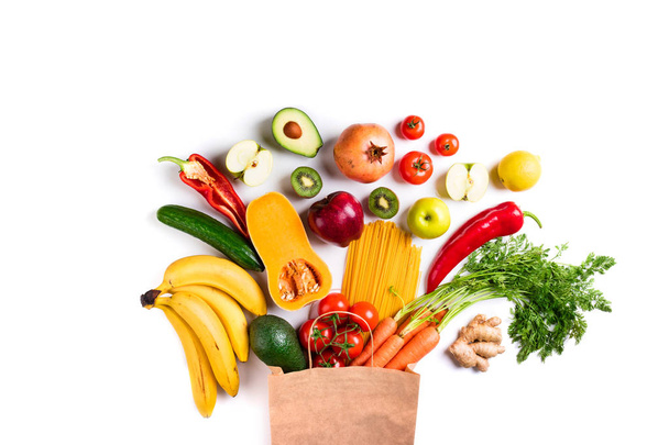 Healthy food background. Healthy food in paper bag pasta, vegetables and fruits on white. Shopping food, vegetarian concept - Photo, Image
