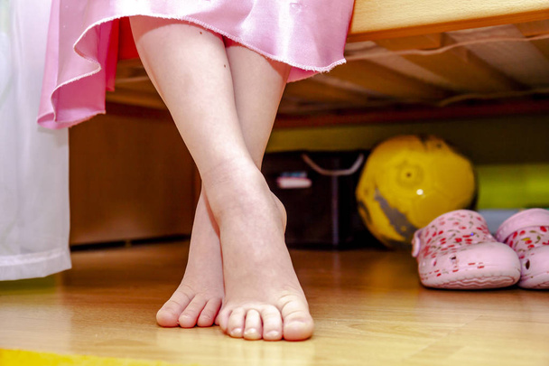 Close-up of little girl feet while sitting on bed - Fotoğraf, Görsel