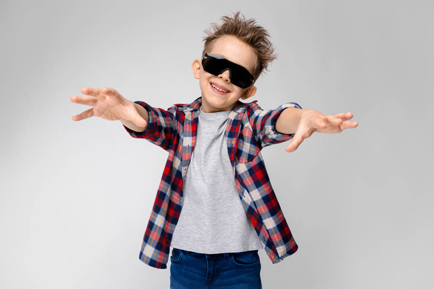 Ładne kaukaski przedszkolak chłopiec dorywczo strój i okulary przeciwsłoneczne, pokazując różne wyrażenia na białej ścianie w studio. - Zdjęcie, obraz