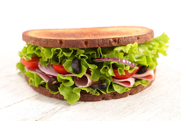Delicious sandwich with ham on wooden board - Fotó, kép