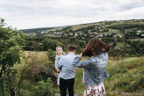 Zadní pohled na mladé rodiny trávit čas spolu chodit na poli - Fotografie, Obrázek