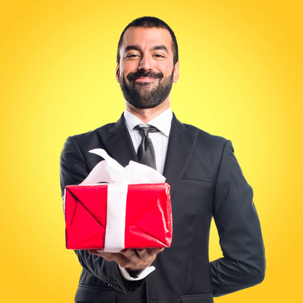 Businessman holding a gift - Fotó, kép