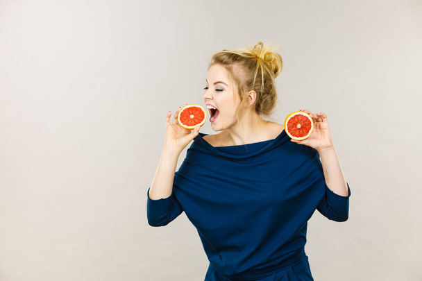 Happy smiling woman holding red grapefruit - Фото, изображение