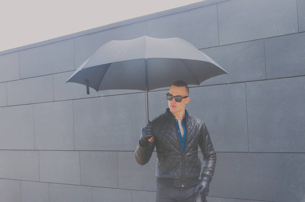 brutal man in a jacket and sunglasses on the street - Foto, Imagen