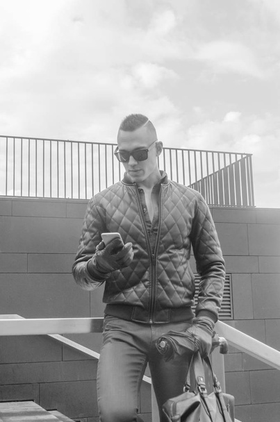 brutal man in a jacket and sunglasses on the street - Foto, Bild