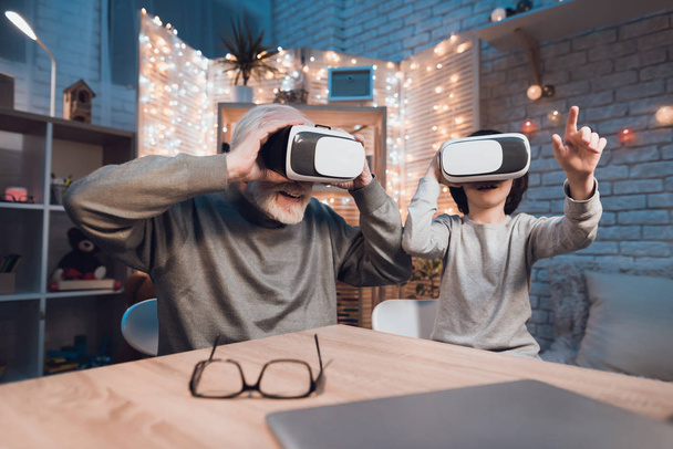 Grandfather and grandson using virtual reality at home - Foto, Bild