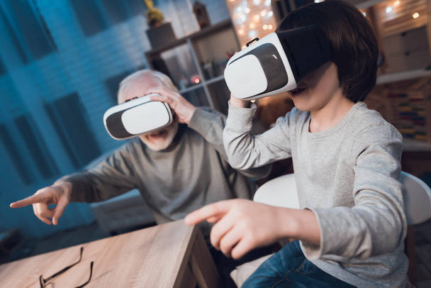 Grandfather and grandson using virtual reality at home - Foto, Imagem