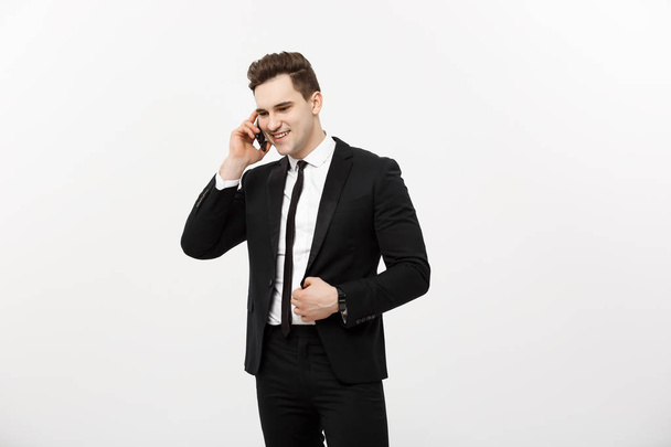 Handsome businessman in suit speaking on the phone over isolated white background. - Foto, afbeelding