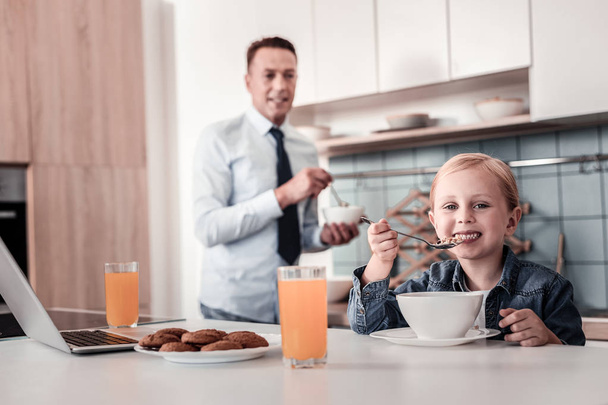Cheerful kid posing on camera while eating - Foto, Bild