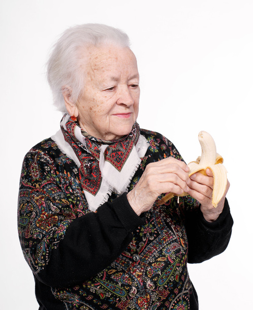 oude vrouw met banaan - Foto, afbeelding