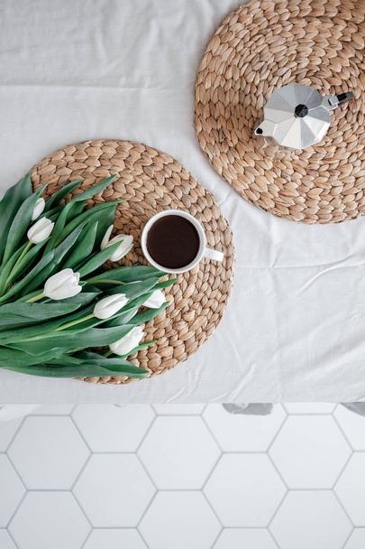 A bouquet of white tulips and a cup of coffee on a table - Valokuva, kuva