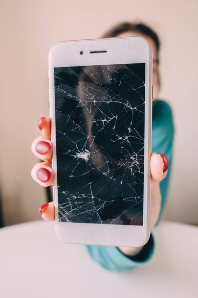 Broken glass screen smartphone in hand, white background - Photo, Image