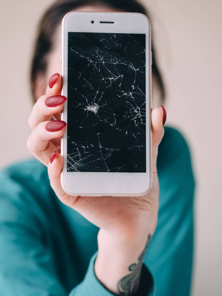 Broken glass screen smartphone in hand, white background - Photo, Image