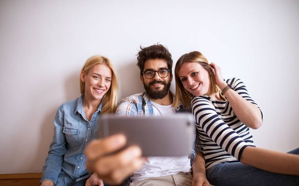 group of young playful coworkers laughing and taking selfie  - Photo, Image