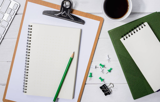 hölzerner weißer Schreibtisch mit Tasse Kaffee, Notizbuch, Stift - Foto, Bild