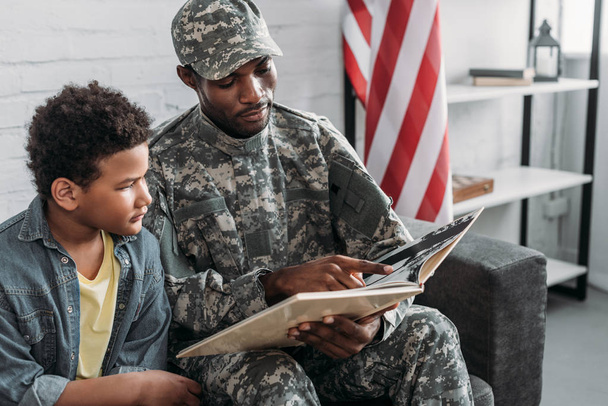 Père en uniforme de l'armée et garçon afro-américain livre de lecture
  - Photo, image