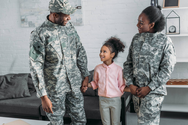 Frau und Mann in Armeeuniform mit ihrer Tochter - Foto, Bild