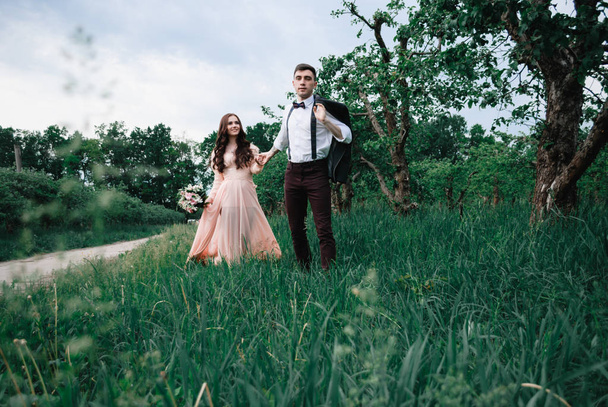 Nice outdoor wedding photography of young beutiful couple in summer park - Фото, изображение