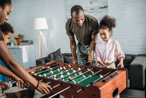 Parents in camouflage clothes playing table football with their kids - Foto, Imagem