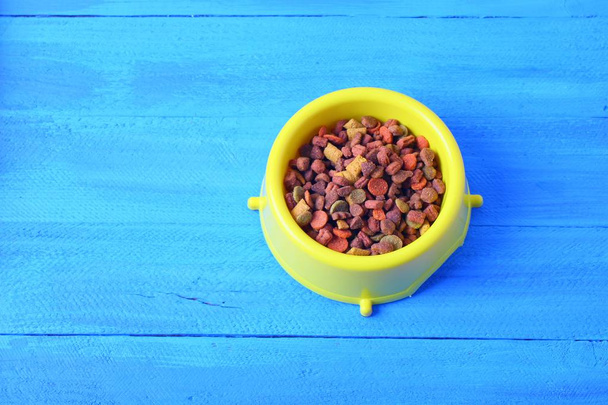 Dry cat food in yellow bowl isolated - Fotografie, Obrázek