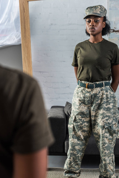 Mujer soldado afroamericana posando junto al espejo
 - Foto, Imagen