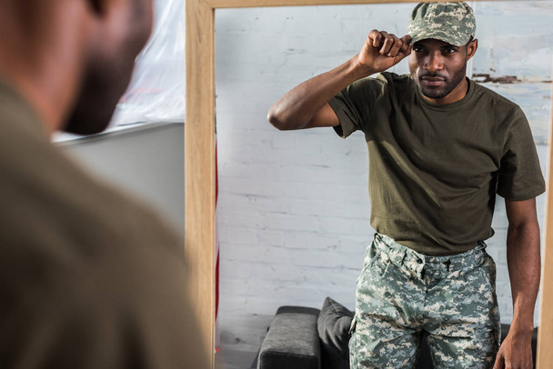 Przystojny Afryki amerykański żołnierz zakładanie WPR przez lustro - Zdjęcie, obraz