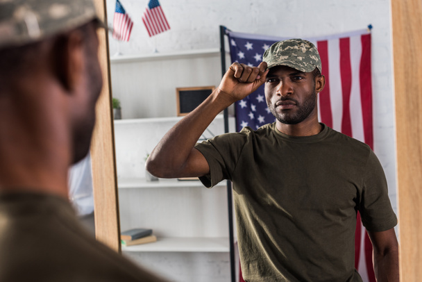 Confident african american man in camouflage clothes posing by the mirror - Fotó, kép