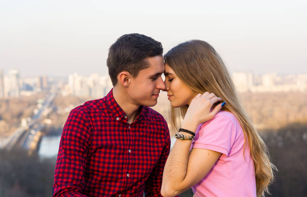 Хлопець збирається поцілувати дівчину на тлі міст
 - Фото, зображення