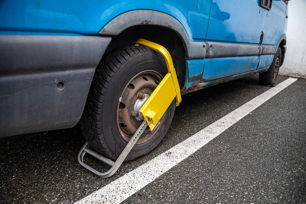 gele wiel blokkeersysteem op een blauwe busje in de Duitsland - Foto, afbeelding