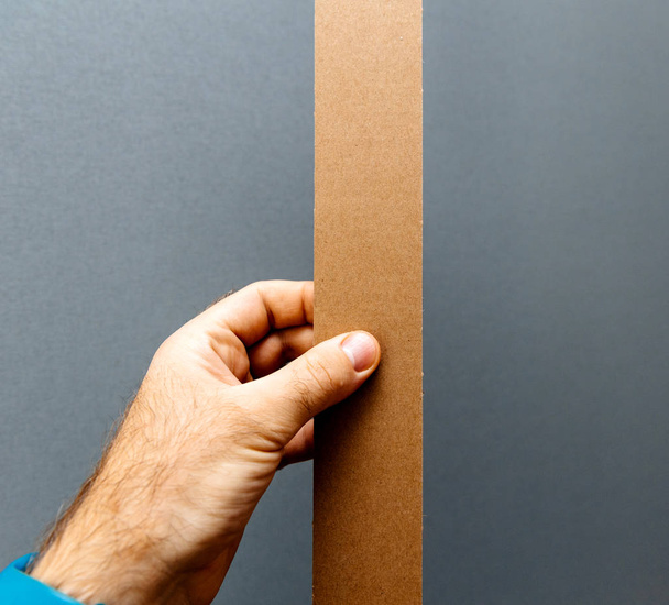 Corrugated cardboard carton paper for packing  in male hand  - Φωτογραφία, εικόνα